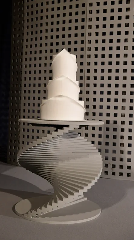 White wedding cake on a spiral staircase stand